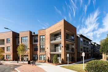 A modern brick apartment building with a clear blue sky above.